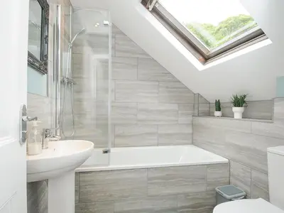 a bathroom with a bath tub and a sink at Albert House in Looe