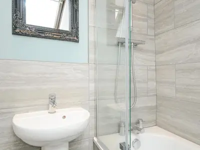 a white bathroom with a sink and a shower at Albert House in Looe