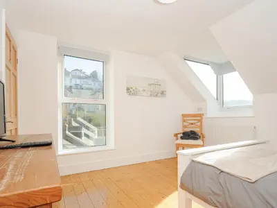 a white room with a bed and two windows at Albert House in Looe