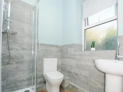 a bathroom with a toilet and a sink and a shower at Albert House in Looe