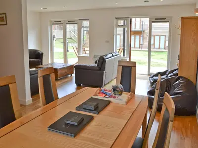 a living room with a wooden table and leather chairs at Porhellik in Zelah