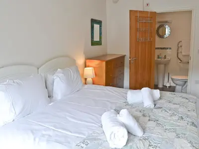 a large white bed with towels on it in a bedroom at Porhellik in Zelah