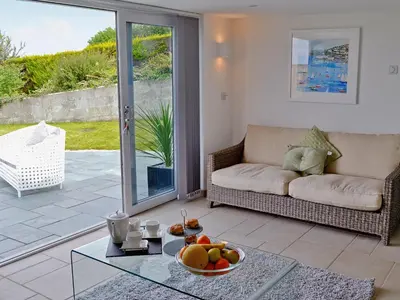 a living room with a couch and a glass table at Sea Vista in Port Isaac