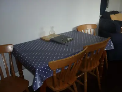 a table with a blue table cloth with a laptop on it at HOPSLAND HOLIDAYS Byre, Dairy & Hayloft in Saint Cleer
