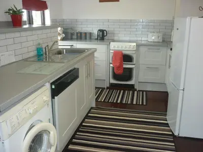 a kitchen with a sink and a dishwasher at HOPSLAND HOLIDAYS Byre, Dairy & Hayloft in Saint Cleer