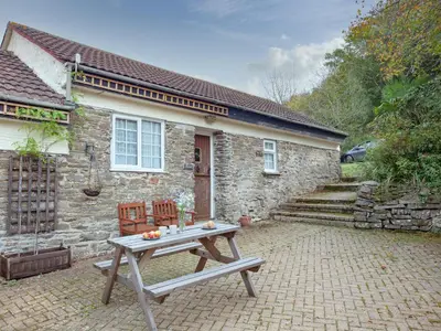 a stone house with a picnic table in front of it at Byre in Saint Martin