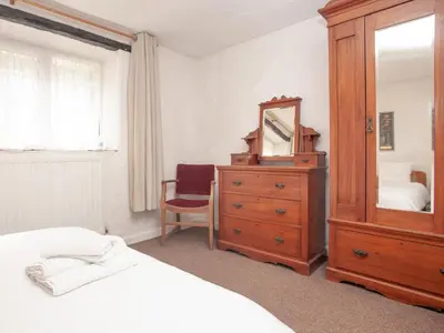 a bedroom with a wooden dresser and a mirror at Byre in Saint Martin