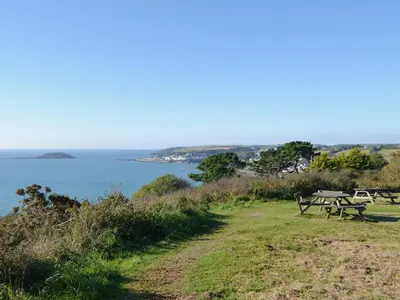 a picnic table on a hill overlooking the ocean at Byre in Saint Martin
