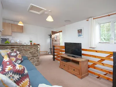 a living room with a blue couch and a television at Smithy in Saint Martin