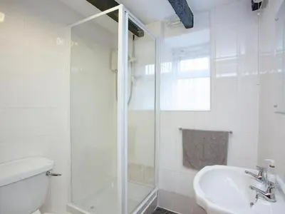 a white bathroom with a shower and a sink at Smithy in Saint Martin
