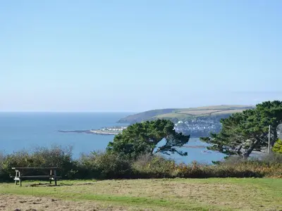 a bench sitting on top of a hill near the ocean at Smithy in Saint Martin