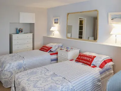 a bedroom with two beds and a mirror at Waterside in Fowey