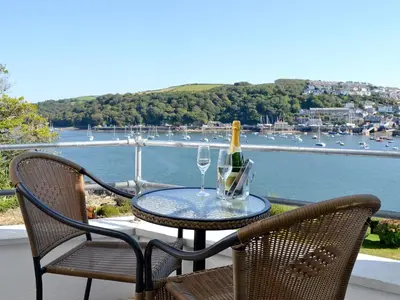 a table with a bottle of wine and two glasses at Waterside in Fowey