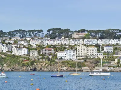 a group of boats in the water in front of a town at Waterside in Fowey