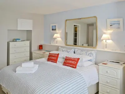 a bedroom with a bed with pillows and a mirror at Waterside in Fowey
