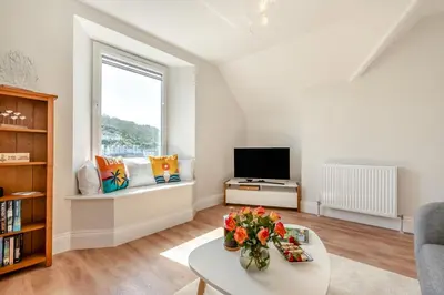 a living room with a table and a tv at 1 Bed in Looe oc-s29019 in Looe