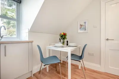 a white table with blue chairs in a room at 1 Bed in Looe oc-s29019 in Looe