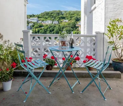 a table and two chairs on a balcony with flowers at 1 Bed in Looe oc-s29019 in Looe