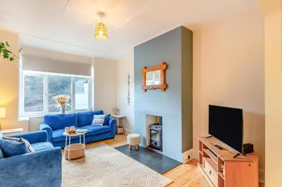 a living room with a blue couch and a tv at 3 Bed in Looe oc-s29266 in Looe