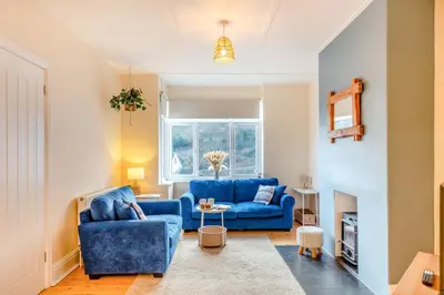 a living room with blue couches and a fireplace at 3 Bed in Looe oc-s29266 in Looe