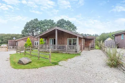 a cabin with a porch and a fence in front of it at 2 Bed in Winnards Perch oc-s29311 in Saint Columb Major