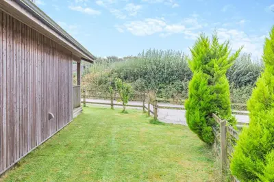 a yard with a fence and trees next to a building at 2 Bed in Winnards Perch oc-s29311 in Saint Columb Major
