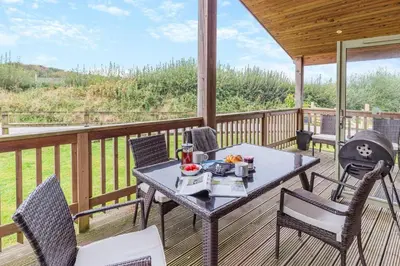 a porch with a table and chairs on a deck at 2 Bed in Winnards Perch oc-s29311 in Saint Columb Major