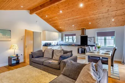 a living room with a couch and a table and a kitchen at 2 Bed in Winnards Perch oc-s29311 in Saint Columb Major