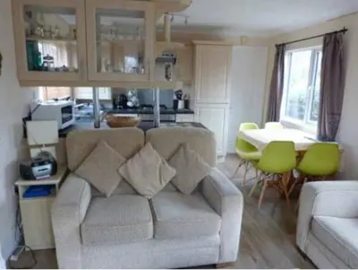 a living room with a couch and a table at Rosewater Park Lodge in Bodmin