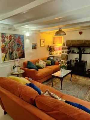 a living room with orange couches and a fireplace at Redmoor in Saint Day