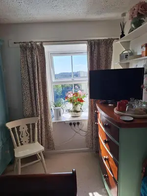 a room with a window and a chair and a dresser at Redmoor in Saint Day
