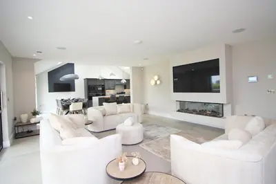 a living room with white furniture and a fireplace at Luxury holiday home with HOT TUB in St Merryn