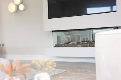 a living room with a tv and a mirror at Luxury holiday home with HOT TUB in St Merryn