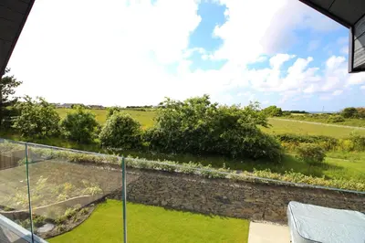 a view of the garden from the balcony of a house at Luxury holiday home with HOT TUB in St Merryn