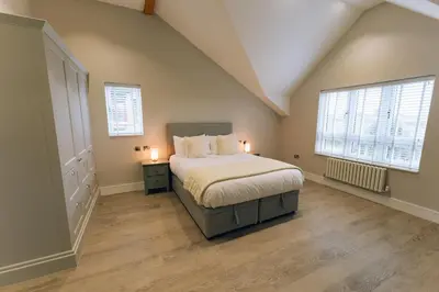 a bedroom with a bed and two windows at Luxury holiday home with HOT TUB in St Merryn