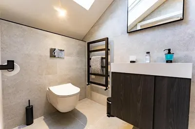 a bathroom with a toilet and a sink and a skylight at Luxury holiday home with HOT TUB in St Merryn