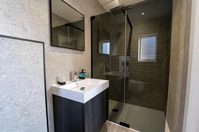 a bathroom with a white sink and a shower at Luxury holiday home with HOT TUB in St Merryn