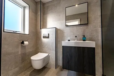 a bathroom with a toilet and a sink and a mirror at Luxury holiday home with HOT TUB in St Merryn