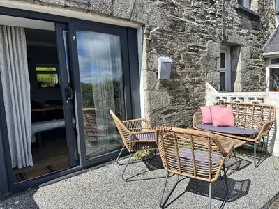 a couple of chairs sitting on a patio at The Little Cottage at Porth in Newquay