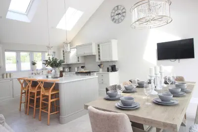 a kitchen and dining room with a table and chairs at Stylish home with HOT TUB in St Merryn