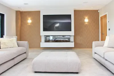 a living room with two couches and a flat screen tv at Stylish home with HOT TUB in St Merryn