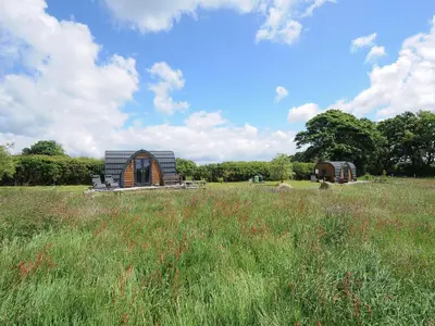 a small wooden cabin in a field of grass at Rowan in Launceston