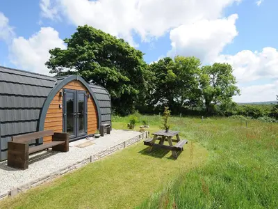 a small cabin with a picnic table in a field at Hornbeam in Launceston