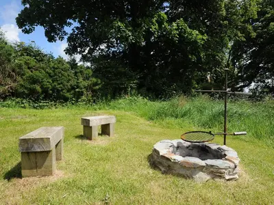 two benches and a fire pit in a field at Hornbeam in Launceston
