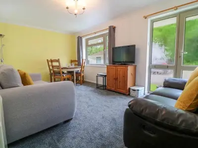 a living room with a couch and a tv at Beekeepers Cottage in Liskeard