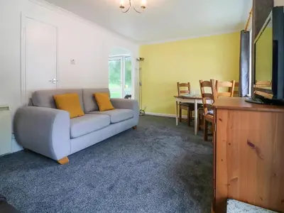 a living room with a couch and a dining room at Beekeepers Cottage in Liskeard