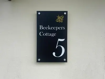 a sign for a beehives conference on a wall at Beekeepers Cottage in Liskeard