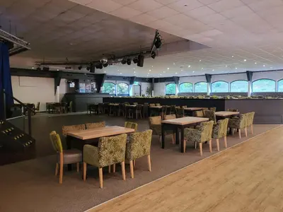 a dining room with tables and chairs and a bar at Bumbeldink in Uny Lelant
