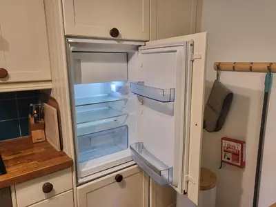 an empty refrigerator with its door open in a kitchen at Bumbeldink in Uny Lelant