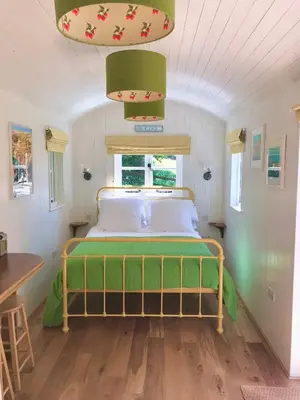 a bedroom with a bed in a small room at Shepherd's hut at Rosewood House in Liskeard